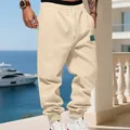 Detail of men's cream fleece-lined joggers with drawstring waist and tapered cuffs in resort setting. - S / Bottoms / Apricot