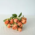 Vista detallada de un ramo de 11 rosas artificiales naranjas para decoración de mesa - Champaña Profundo