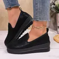 Detailed view of black platform slip-on loafers with textured finish on model feet - 36 / Black