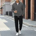 Tuta sportiva casual da uomo grigia con giacca a zip e pantaloni sportivi neri da esterno. - Grigio