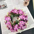 Detailaufnahme eines rosa-weißen Wildblumenkranzes auf altem Zeitungshintergrund - Fuchsie
