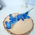 Vivid blue artificial butterfly branch decoration pick displayed on a wooden slice - Blue