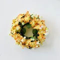 Primo piano di una ghirlanda di candele con fiori selvatici artificiali arancio e bianchi - Arancione