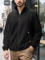 Detail view of men's black polar fleece jacket with zip and pocket accents outdoors. - S / Tops / Black