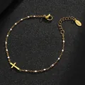 Detailed view of a gold stainless steel cross bracelet with white enamel beads - Gold Purity / White