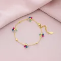 Close-up detail of a gold stainless steel bracelet with colorful crystal flower charms - Colorful