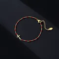 Detailansicht des goldenen Edelstahl-Kreuzarmbands mit roten Emaille-Perlen. - Gold Reinheit / Rot