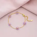 Detailed view of gold titanium steel bracelet with purple crystal flower charms. - Purple