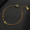 Detailed view of gold stainless steel cross bracelet with orange enamel beads - Gold Purity / Orange