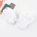 Close-up of white baby girl socks with double-layer lace ruffles and satin bow - One Size (0-1 Year Old) / White