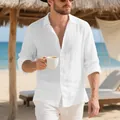 Lifestyle detail shot of a man wearing a white loose-fit linen shirt on a sunny beach - S / Tops / White