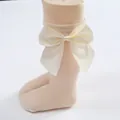 Adorable cream baby knee high socks featuring a large decorative satin bow detail - Beige