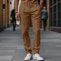 Close-up of men's slim-fit brown trousers with drawstring waist and stitched creases. - Camel