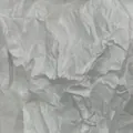 Close-up detail of white wrinkled crepe paper showing realistic DIY craft texture - White