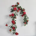 Close-up detail of artificial red rose vine garland hanging on white wall background - Rose Vine / Dark Red