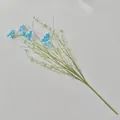 Detail view of artificial blue daisy branch with green stems on white background - Blue