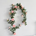 Detail showing pink artificial rose vine with realistic green leaves on a white wall - Rose Vine / Light Pink
