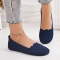 Close-up detail of navy blue flyknit slip-on ballet flats featuring a textured scallop edge - Blue