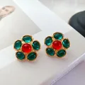 Vue détaillée des boucles d'oreilles fleurs vintage avec gemmes rouges et vertes, fini or. - Vert et Rouge