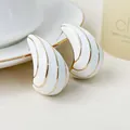 Detailed macro view of white enamel waterdrop earrings featuring luxury gold line accents - Milky White