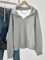 Detailansicht eines grauen Sweatshirts mit halbem Reißverschluss und weichem Fleece-Stoff. - XL / Oberteile / Grau
