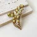 Vintage enamel lily of the valley brooch with rhinestones on a textured stone base. - Lily of the Valley Brooch
