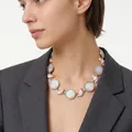 Detailed view of a vintage cameo necklace featuring pink resin pig charms on a female model. - Apricot Cat