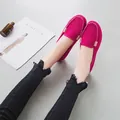 Dettaglio di mocassini in camoscio fucsia con fibbie dorate e jeans sfrangiati - Rosso rosa / 35