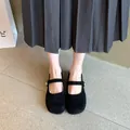 Vista detallada de zapatos Mary Jane de ante negro combinados con falda plisada gris. - 35 / Negro
