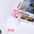 Close-up of pink leather flamingo keychain with fluffy white pom-pom and gold clip. - White