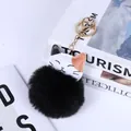 Close-up of a cat pom-pom keychain with black faux fur and a golden clasp ring - Fortune Cat Shape / Black