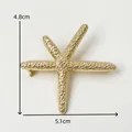 Gedetailleerde weergave van een goudkleurige zeesterbroche met textuur, 4,8x5,1 cm - Zeester broche