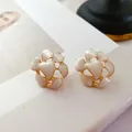 Nahaufnahme von Vintage-Emaille-Blumenohrsteckern mit cremefarbenen Blütenblättern - Künstliche Perle Weißes Herz