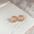 Macro view of vintage French enamel stud earrings featuring delicate pearl trim and gold finish. - Pink Post
