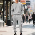 Model draagt een grijze zware fleece sweatshirt en cargo joggingbroek set in een stadsstraat - Lichtgrijs