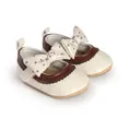 Detail view of cream baby girl princess shoes with brown trim and polka dot bow - Insole Length 11cm / Apricot