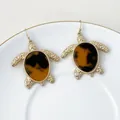 Detalle de pendientes de tortuga vintage únicos con caparazones veteados en ámbar. - Ámbar