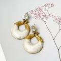 Primer plano detallado de pendientes de pavo real vintage con resina de mármol blanco - Blanco lechoso