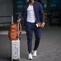 Stilsicherer Mann in einem marineblauen, lässigen Outdoor-Sport-Zweiteiler am Flughafen - S / Oberteil Und Unterteil / Marineblau