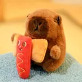Cute Capybara plush toy holding a hot dog plush on a blue textured surface. - Holding Hotdog