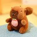 Adorable brown capybara plush toy holding a small pink strawberry fruit accessory - Angel Capybara with Strawberry