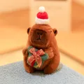Festive Christmas capybara plush toy wearing a Santa hat and holding a gift box - Holding Christmas Gift