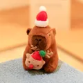 Cute Christmas Capybara plush toy wearing a Santa hat and holding a reindeer doll. - Holding Christmas Reindeer