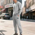 Dettaglio del set felpa e pantaloni sportivi in pile pesante grigio su modello maschile - Grigio chiaro
