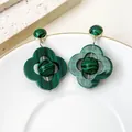 Détail rapproché des boucles d'oreilles trèfle vintage avec motif malachite - Vert
