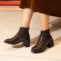 Detail van donkerbruine Chelsea boots met krokodillenprint en blokhak op model - 38 / Donkerbruin