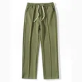 Detailed view of olive green waffle knit men's pants with a drawstring elastic waist. - Army Green