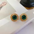 Vue détaillée de boucles d'oreilles vintage en or avec des pierres vert émeraude rondes - Cercle Vert