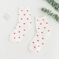 Cute white cotton crew socks featuring a vibrant repeating red heart pattern design - One Size / All-over Heart Print