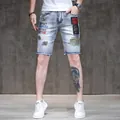 Front view of men's slim embroidered denim shorts with frayed hems and cool patches. - 28 / Bottoms / Light Blue